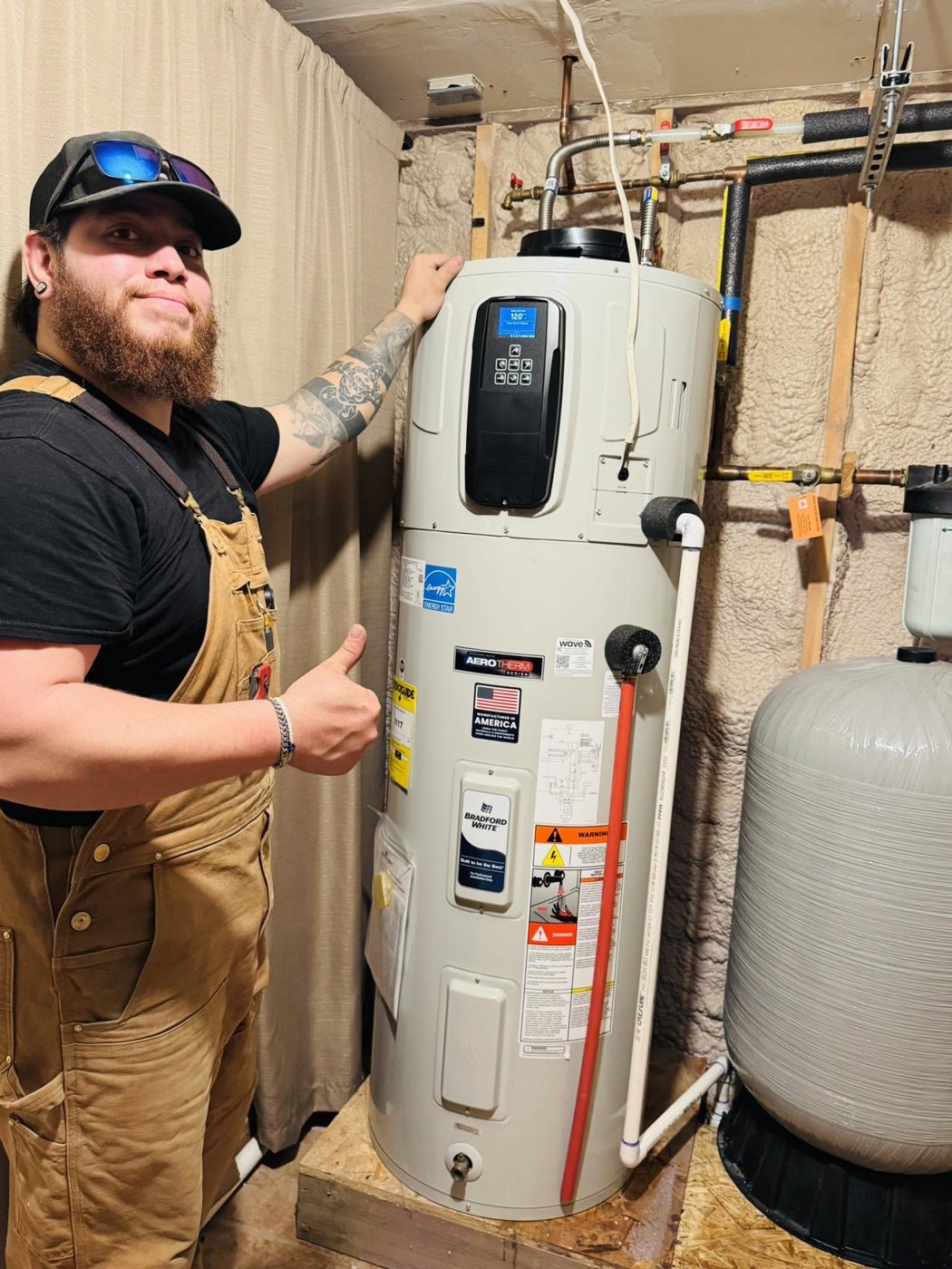 Plumber giving a thumbs-up beside a newly installed Bradford White water heater